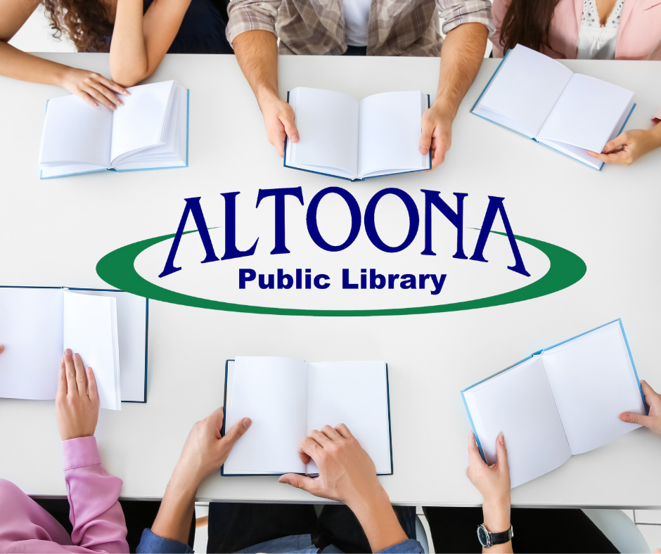 Group sitting around table with library logo in middle