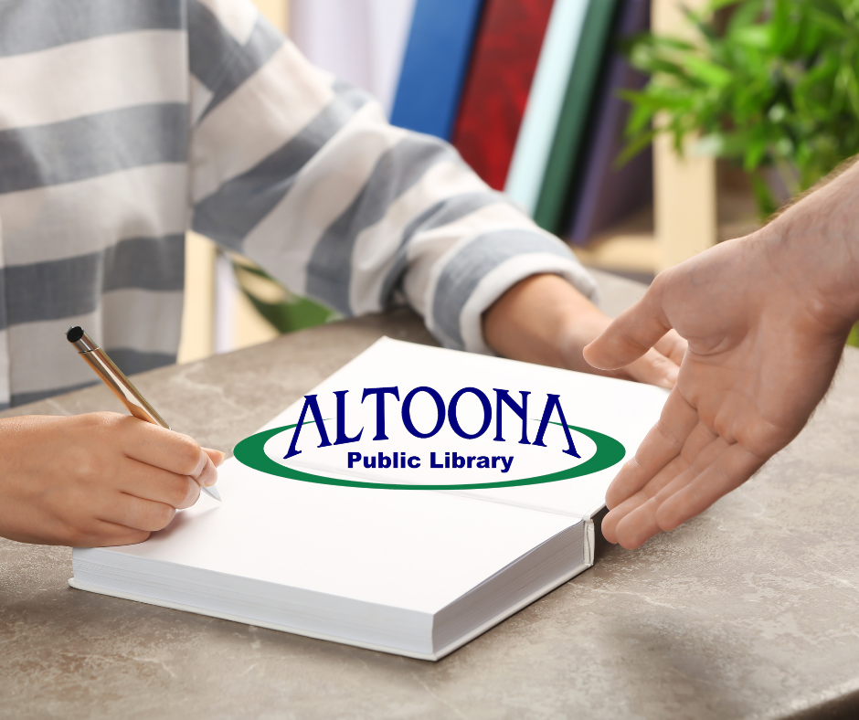 Author signing book with library logo on center of book