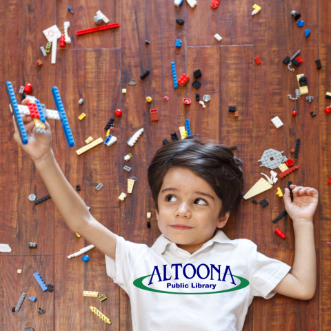 boy on floor surrounded by legos