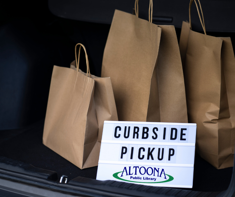 Bags in car trunk with sign that says curbside pickup and library logo on bottom